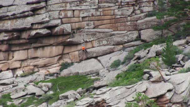 Человек спускается со скалы — стоковое видео