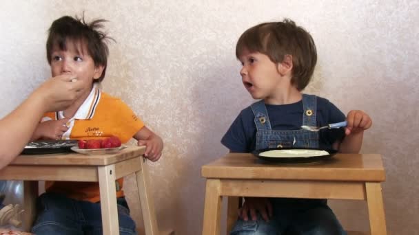 Dos chicos graciosos comiendo gachas — Vídeo de stock