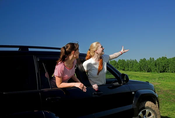 Kvinnor som söker ut bil fönstret Royaltyfria Stockfoton
