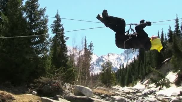 Turista attraversare il fiume di montagna su corda — Video Stock