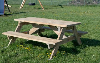 Çayırda bankları olan ahşap masa. 