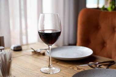 Lokantadaki masada bir bardak kırmızı şarap. 