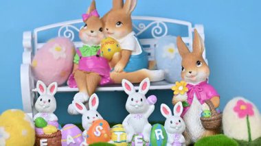 Yeşil çimlerin üzerinde yumurtaları olan tavşanların güzel bir Paskalya süslemesinin videosu..