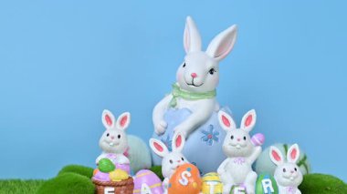 Yeşil çimlerin üzerinde yumurtaları olan tavşanların güzel bir Paskalya süslemesinin videosu..