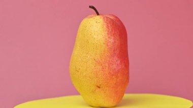 Güzel sarı ve kırmızı bir armudun yakın çekim videosu.