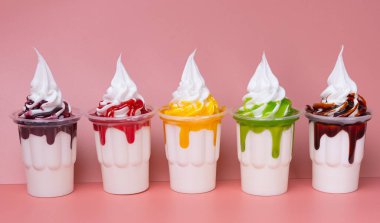 Dondurma, pembe arka planda yakın plan bir bardakta sallanır.