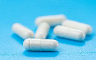 Mavi arkaplan üzerindeki beyaz kapsüller