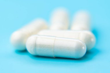 Mavi arkaplan üzerindeki beyaz kapsüller