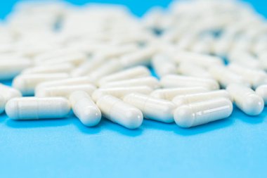 Mavi arkaplan üzerindeki beyaz kapsüller