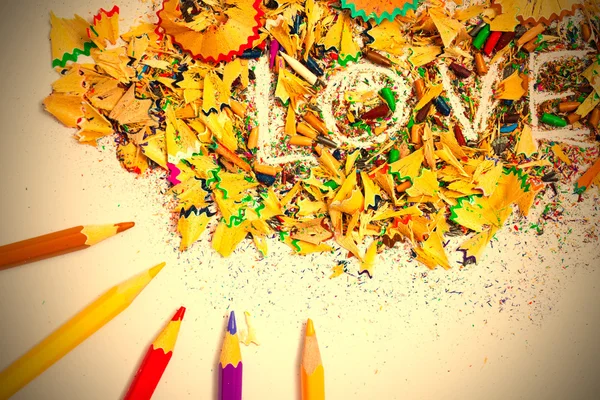 The word LOVE on the background of pencil shavings