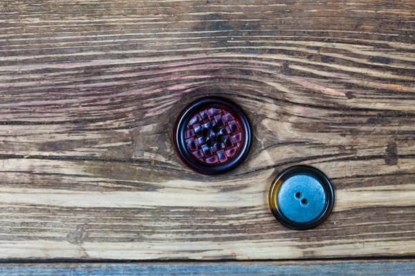 two vintage buttons on aged wood surface