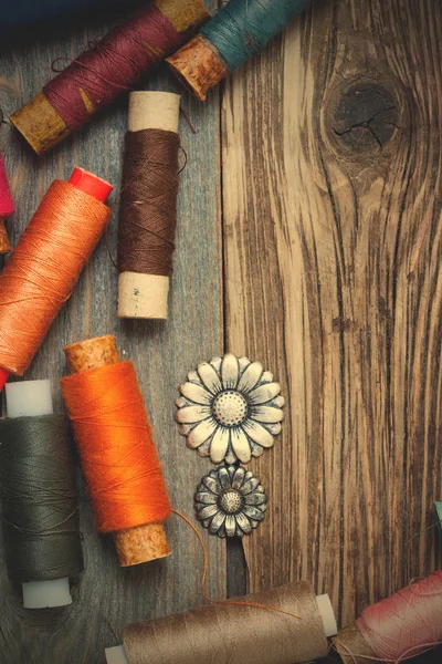 Vintage buttons and old reels of varicolored thread on the text