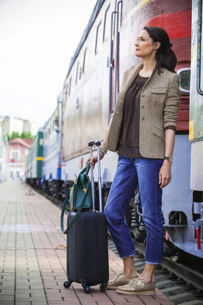 beautiful middle-aged woman with luggage rides in retro trip