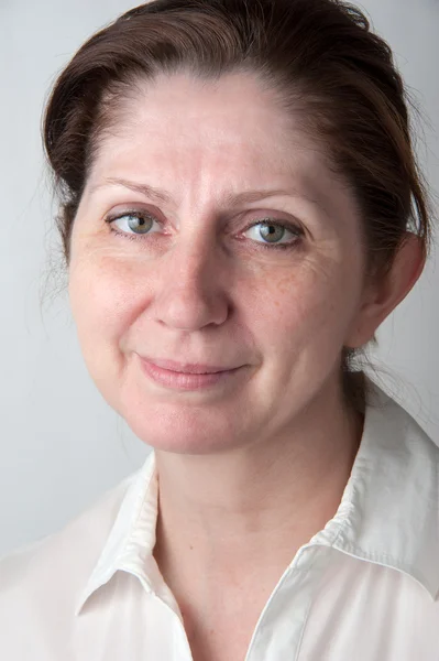 Retrato de uma mulher adulta em uma blusa branca . — Fotografia de Stock