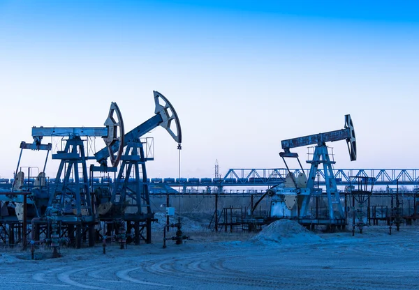 Bombas de óleo em um campo de petróleo . — Fotografia de Stock