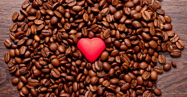 Corazón rojo en granos de café —  Fotos de Stock