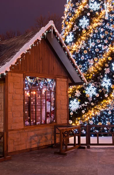 Christmas tree and wooden Santa's house — Stock Photo, Image