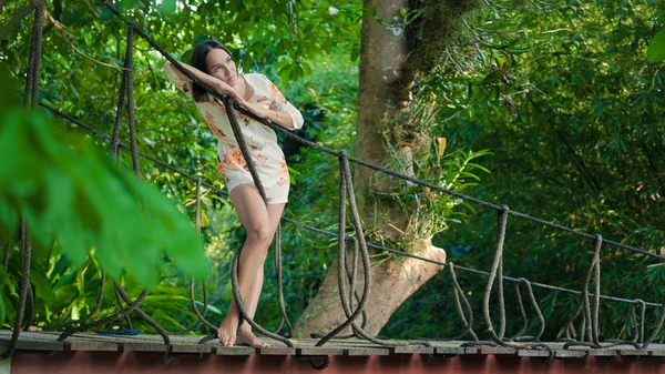 Young woman is relaxing on the hanging bridge — Stock Photo, Image