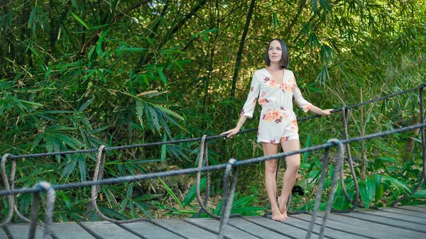 Young woman is relaxing on the hanging bridge — Stock Photo, Image