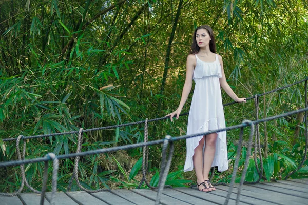 Young woman is relaxing on the hanging bridge — Stock Photo, Image