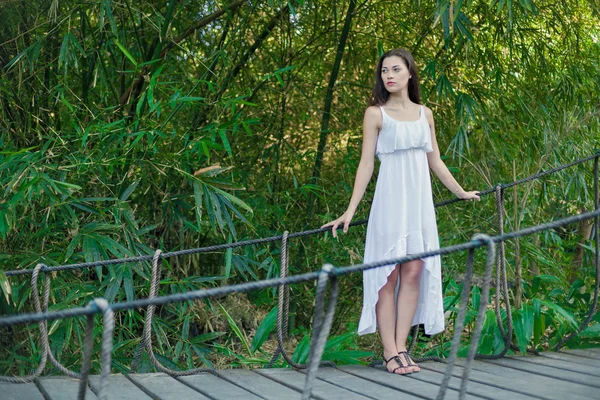 Giovane donna si sta rilassando sul ponte sospeso — Foto Stock