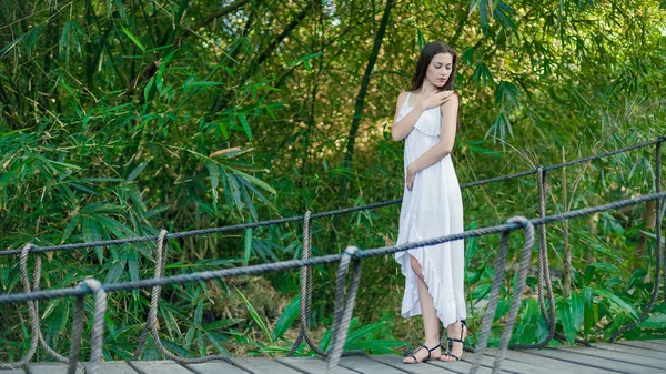 Mujer joven se relaja en el puente colgante — Foto de Stock