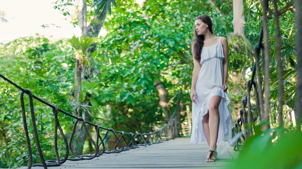 Young woman is walking on the hanging bridge — Stock Photo, Image