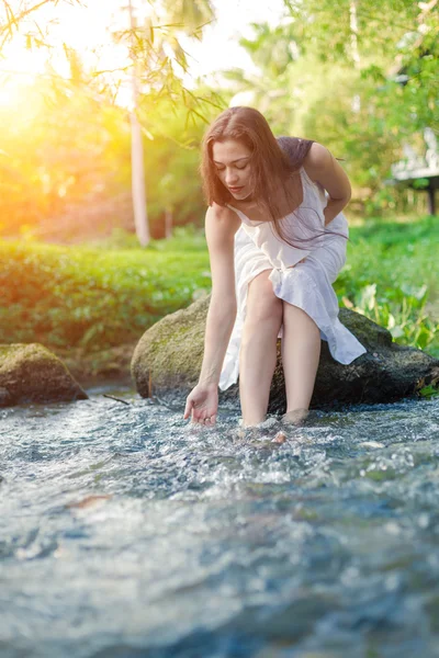 Jovem mulher no vestido branco está sentado na pedra no mi — Fotografia de Stock