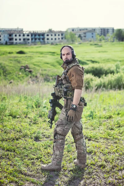 Soldato con il fucile sullo sfondo della città in rovina . — Foto Stock