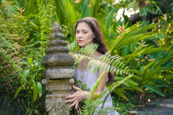 Young woman in white dress near vintage statue — Stock Photo, Image