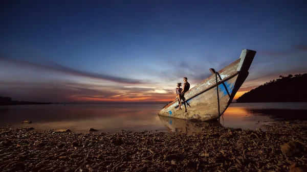 Genç çift batık gemi üzerinde oturuyor — Stok fotoğraf