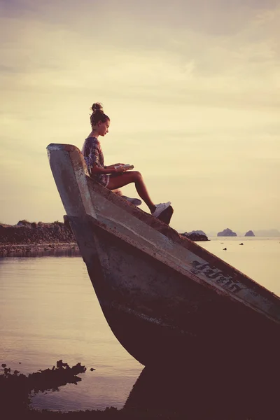 Jovem está sentada no naufrágio e lendo um livro . — Fotografia de Stock
