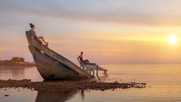 Jovem casal no navio afundado está olhando para o sol tropical — Fotografia de Stock