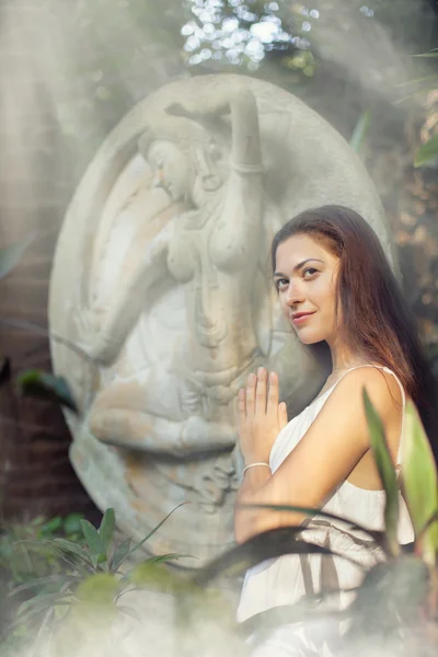 Mujer joven está haciendo yoga en el fondo de la estatua antigua . —  Fotos de Stock