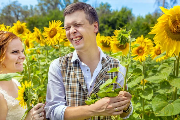 Lustiger Mann in karierter Weste mit der Sonnenblume in der Hand. — Stockfoto