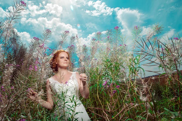 Mulher bonita em vestido branco entre flores gigantes mágicas . — Fotografia de Stock
