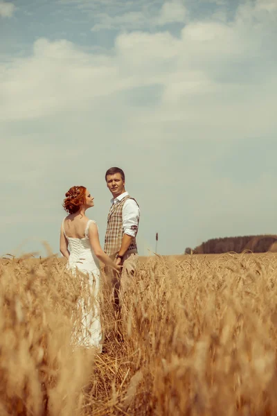 Feliz casal abraçando no fundo do campo de trigo . — Fotografia de Stock