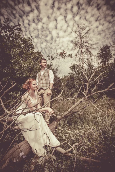 Casal feliz está sentado no ramo da árvore velha no b rural — Fotografia de Stock