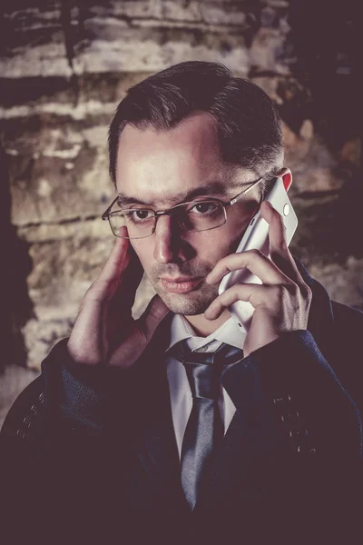 Ernstige zakenman is praten via de telefoon op de nacht rotsen backg — Stockfoto