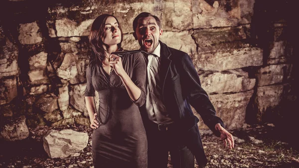 Un par de personas bien vestidas sobre el fondo de rocas oscuras . — Foto de Stock