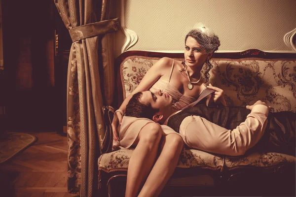 Joven pareja coqueteando está acostada en el sofá. Vintage post proces — Foto de Stock