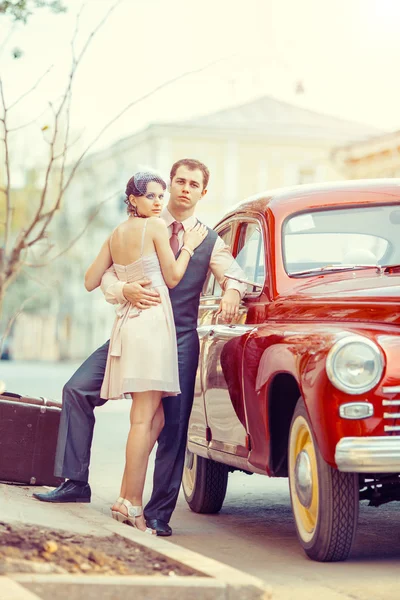 Pretty couple is going to make a jorney on their red car. — Stock Photo, Image