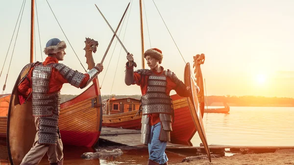 Slaget vid två medeltida riddare med svärd och sköldar. Örlogsfartyg — Stockfoto