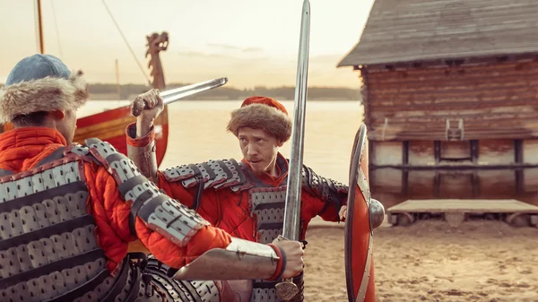 Batalla de dos caballeros medievales con espadas y escudos. Buque de guerra —  Fotos de Stock