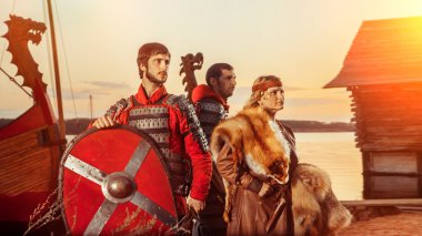 Slav Prenses ve kılıç ve kalkanlar üzerinde savaş gemileri arka plan ile iki savaşçı.