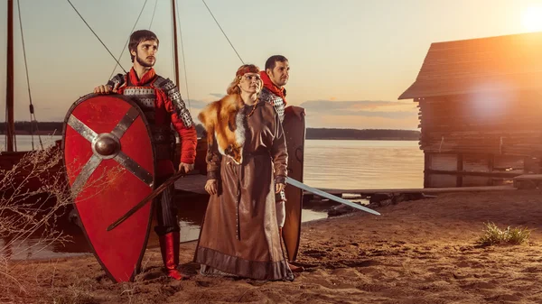 Princesa eslava y dos guerreros con espadas y escudos en el fondo de las naves de guerra . —  Fotos de Stock