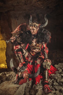 Çelik zırh giyinmiş güzel kadın savaşçı bir balta tutuyor