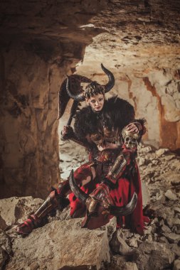 Çelik zırh giyinmiş güzel kadın savaşçı bir balta tutuyor