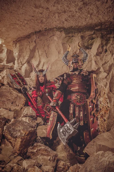 Deux chevaliers en armure avec haches. Catacombes sur le backgroun — Photo