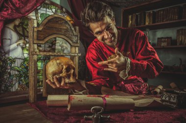 Gülümseyen Ortaçağ büyük el kafatasında işaret ediyor.